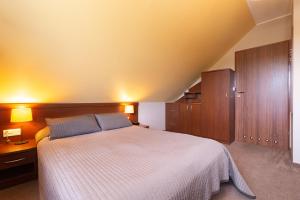sypialnia z dużym łóżkiem i drewnianymi szafkami w obiekcie Dom Wypoczynkowy Rejs w Łebie