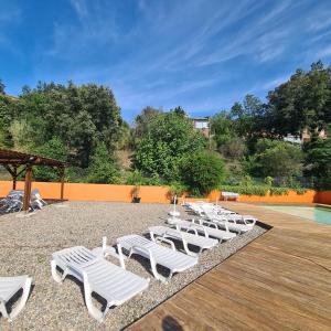 a row of white lounge chairs next to a pool at Entre mer et montagne in Le Boulou +8 photos