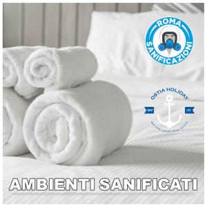 uma pilha de toalhas sentadas em cima de uma cama em Appartamento Mykonos em Lido di Ostia