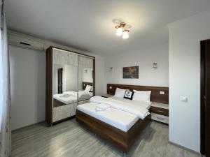 a bedroom with two beds and a large mirror at Casa Lebăda in Jurilovca