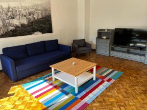 a living room with a blue couch and a coffee table at Hotel & Apartment Am Theaterplatz in Bremerhaven