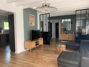 een woonkamer met een bank en een tv bij Villa "OSTAU OCÉANE" in Capbreton