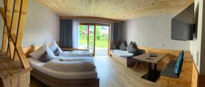 um quarto com uma cama, uma mesa e uma televisão em Hotel Garni Gästehaus Edlhuber em Mittenwald