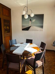 einen Esstisch mit Stühlen und einen Leuchtturm an der Wand in der Unterkunft Hotel & Apartment Am Theaterplatz in Bremerhaven