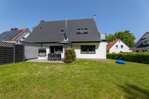 una casa blanca con un patio con un frisbee azul en Haus Hamburg Wohnung 1 en Hohwacht