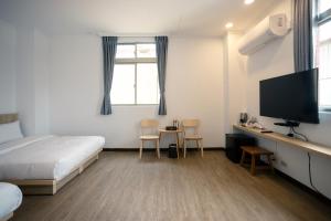 een slaapkamer met een bed en een flatscreen-tv bij 池上大地飯店 in Chishang