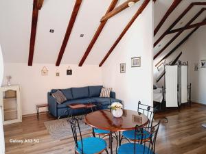 a living room with a blue couch and a table at Studio apartman u renesansnoj vili in Vis