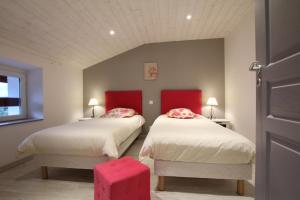 a bedroom with two beds with red headboards at Bidainia in Ainhice-Mongelos