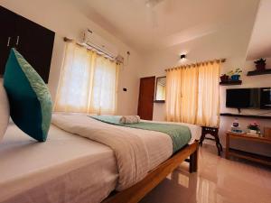 a bedroom with two beds and a television in it at THE LUXE, ECR ROAD, NEAR Serenity Beach, Pondicherry - BMC in Pondicherry