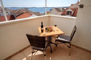 un tavolo con un cesto di frutta e una bottiglia di vino sul balcone di Apartments ''Tri Sestrice'' - ZF Hvar a Hvar