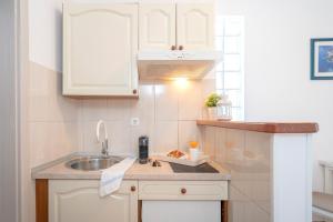 a small kitchen with a sink and a counter top at Apartments ''Tri Sestrice'' - Hvar in Hvar