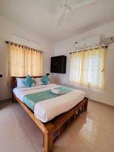 a bedroom with a large bed with blue pillows at THE LUXE HOTEL in Puducherry