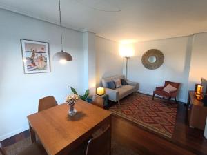 sala de estar con mesa y sofá en Bonito duplex cerca de la playa y de Santander, en Santa Cruz de Bezana