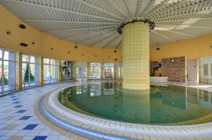 a swimming pool in a building with a large ceiling at Galéria šťastia DS, balneológia in Dunajská Streda