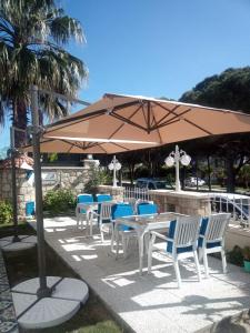 - une table et des chaises sous un parasol sur la terrasse dans l'établissement Aral Turkuaz, à Çeşme