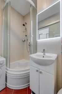 ein weißes Bad mit einem Waschbecken und einer Dusche in der Unterkunft Studio Apartment Anita with balcony in Split