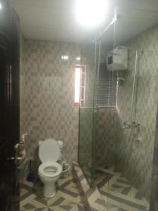 a bathroom with a toilet and a glass shower at Dee Rocket in Ibadan