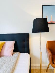 a bedroom with a bed with a black headboard and a lamp at Scandinavian Apartment Hotel -Lunden 2- Central 2 room apartment in Horsens