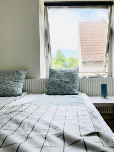 a bedroom with a bed and a large window at Scandinavian Apartment Hotel -Lunden 2- Central 2 room apartment in Horsens