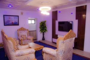 a living room with chairs and a table and a tv at Dee Rocket in Ibadan