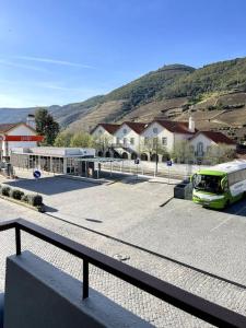 un autobús estacionado en un estacionamiento al lado de un edificio en Casa das Amigas, en Pinhão