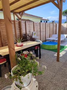 a patio with a wooden pergola and a table with plants at House Viareggio in Viareggio