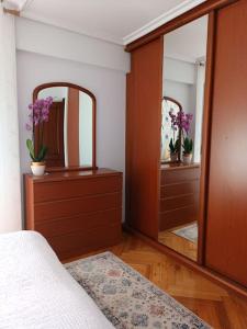 ein Schlafzimmer mit 2 Spiegeln, einem Bett und einer Kommode in der Unterkunft Centro. Bahía. Estaciones. in Santander