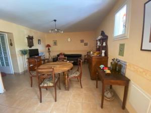 a living room with a wooden table and chairs at Les Oliviers in Montagnac