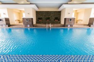マニラにあるPacific Bay Grand Suitesの青い水のホテルのスイミングプール