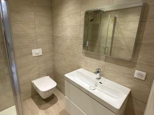 a bathroom with a sink and a toilet and a mirror at Alivu - Appartement Moderne Avec Terrasse in Cargèse