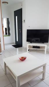 sala de estar con mesa blanca y TV en HOUSE CLOSE TO ROYAN AND SEASIDE, GROUND FLOOR, QUIET AND COMFORTABLE, en Médis