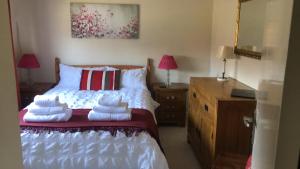 ein Schlafzimmer mit einem Bett mit Handtüchern darauf in der Unterkunft Captivating 2-Bed House in Amesbury Salisbury in Amesbury