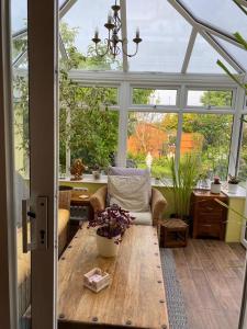 einen Wintergarten mit einem Sofa und einem Tisch in einem Zimmer in der Unterkunft Captivating 2-Bed House in Amesbury Salisbury in Amesbury