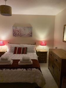 sypialnia z łóżkiem z 2 stolikami nocnymi i 2 lampami w obiekcie Captivating 2-Bed House in Amesbury Salisbury w mieście Amesbury