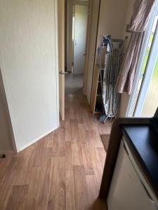 a hallway with an open door and a wooden floor at Ocean View B3 in Hartlepool