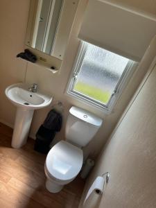 a bathroom with a toilet and a sink and a window at Ocean View B3 in Hartlepool
