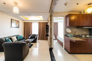 a living room with a couch and a kitchen at Pacific Bay Grand Suites in Manila