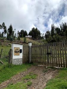 a wooden fence with a dog picture on it at Cabaña en la montaña de 3 Habitaciones in Sutatausa