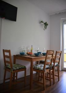 a dining room table with two chairs and a television at Helikon 31 Apartman Keszthely in Keszthely