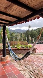 a hammock hanging from a porch with a view at Cabaña en la montaña de 3 Habitaciones in Sutatausa