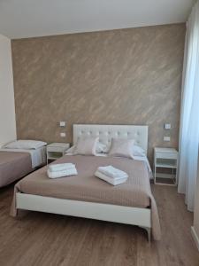 a bedroom with two beds with towels on them at City Center Suite in Termoli