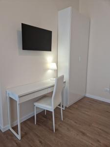 a white desk with a chair and a television on a wall at City Center Suite in Termoli