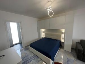 um quarto com uma cama azul e um sofá em Infinity Residence con Parcheggio em Porto Cesareo