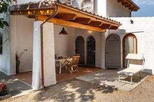 a patio with a table and a wooden pergola at Villetta sogno d'estate in Flumini di Quartu