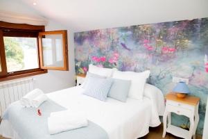 a bedroom with two beds and a floral wall at Casa da Marisma in Redondela
