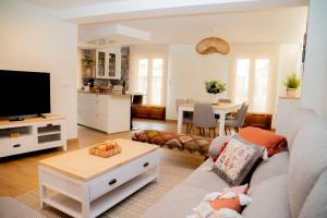 ein Wohnzimmer mit einem Sofa und einem TV in der Unterkunft Casa da Marisma in Redondela