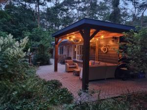 - un kiosque avec un canapé sur une terrasse en briques dans l'établissement Holiday home bos en heide, à Otterlo