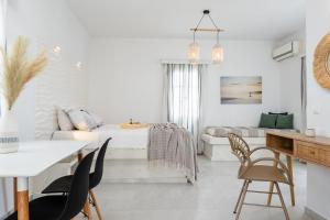 a white room with a bed and a table and chairs at Diamantis Studios&Apartments in Mikri Vigla