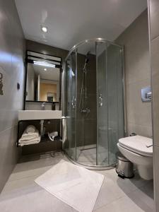 a bathroom with a glass shower and a toilet at Sezer's Oliva Hotel in Canakkale