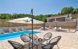 una mesa con sombrilla junto a la piscina en Nice Home In Zmijavci With Private Swimming Pool, Can Be Inside Or Outside, en Zmijavci